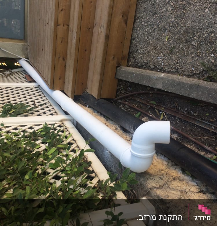 צינור לבן על גג עץ ליד קיר